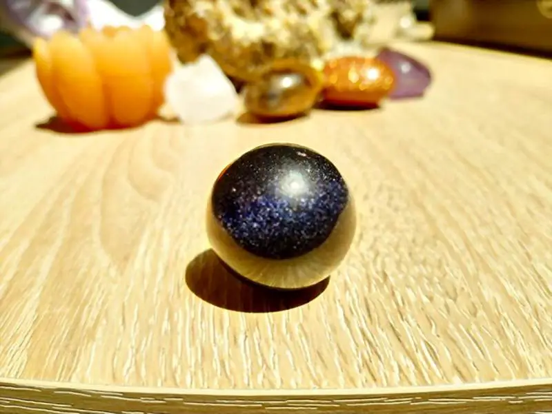 Blue Goldstone Sphere on wooden table